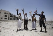 Houthi rebels hold up their weapons as they chant slogans at the residence of a military commander of the Houthi militant group destroyed by a Saudi-led airstrike, Sanaa, Yemen, April 28, 2015 (AP photo by Hani Mohammed).