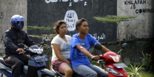Motorists ride past graffiti of the Islamic State flag in Solo, Central Java, Indonesia, March 8, 2014 (AP photo).