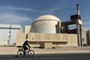 A worker rides a bicycle in front of the reactor building of the Bushehr nuclear power plant, outside the southern city of Bushehr, Iran, Oct. 26, 2010 (AP Photo/Mehr News Agency, Majid Asgaripour).