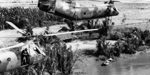 U.S. door gunners in H-21 Shawnee gunships look for a suspected Viet Cong guerrilla who ran to a foxhole from the sampan on the Mekong Delta river bank, Jan. 17, 1964 (AP photo by Horst Faas).