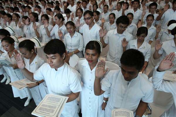 New Filipino professional nurses take their oaths during a ceremony at a convention center, Manila, Philippines, Sept. 20, 2010 (AP photo by Bullit Marquez).