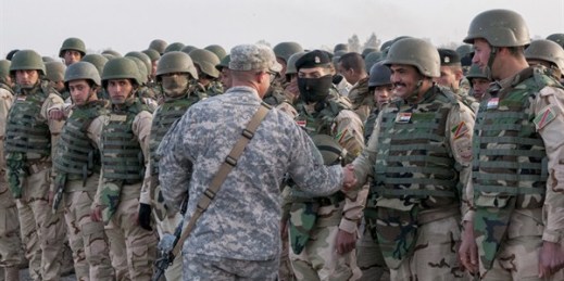 U.S. soldier congratulates Iraqi army trainees on their graduation from a six-week training course at Camp Taji, north of Baghdad, Iraq, Feb. 13, 2015 (U.S. Army photo by Staff Sgt. Daniel Stoutamire).