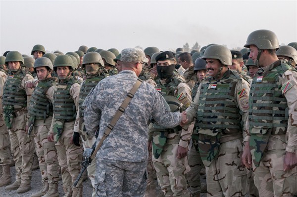 U.S. soldier congratulates Iraqi army trainees on their graduation from a six-week training course at Camp Taji, north of Baghdad, Iraq, Feb. 13, 2015 (U.S. Army photo by Staff Sgt. Daniel Stoutamire).