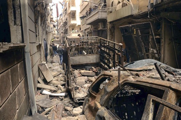Syrians gather in a street that was hit by shelling, in the predominantly Christian and Armenian neighborhood of Suleimaniyeh, Aleppo, Syria, April 11, 2015. (AP Photo/Syrian official news agency SANA).