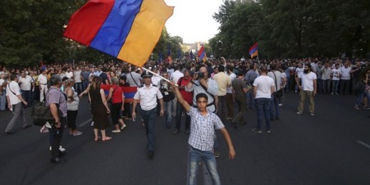 An Armenian protester waves a national flag during a protest against a hike in electricity prices, Yerevan, Armenia, June 22, 2015 (Hrant Khachatryan/PAN Photo via AP).
