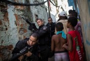 Police Special Operations Battalion (BOPE) officers patrol as residents move about the Sao Carlos slum complex in Rio de Janeiro, Brazil, May 15, 2015 (AP photo/Felipe Dana).