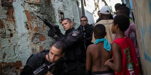 Police Special Operations Battalion (BOPE) officers patrol as residents move about the Sao Carlos slum complex in Rio de Janeiro, Brazil, May 15, 2015 (AP photo/Felipe Dana).