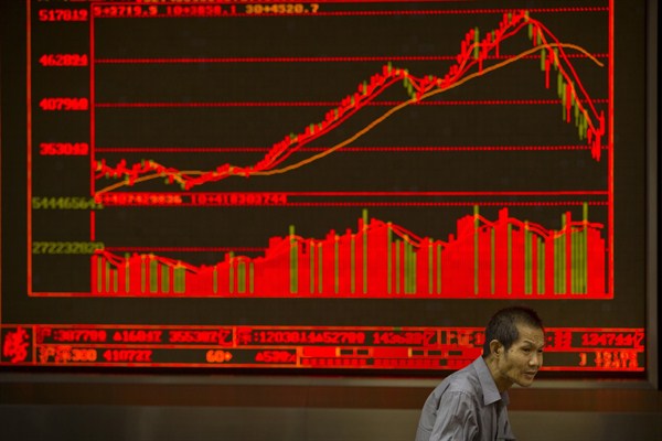 A Chinese investor sits near a displays of stock information in a brokerage house, Beijing,, July 10, 2015 (AP photo by Mark Schiefelbein).