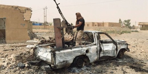 A militiaman allied with the Iraqi security forces dismantles a weapon from a destroyed vehicle belonging to the Islamic State group, southern Ramadi, Anbar province, Iraq, July 20, 2015 (AP Photo).
