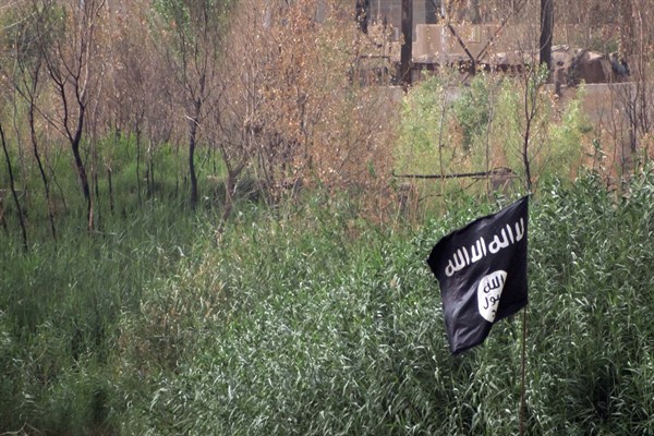 A black flag used by the Islamic State group extremists flutters over their combat positions, outside of Ramadi, Anbar province, Iraq, May 29, 2015 (AP photo).