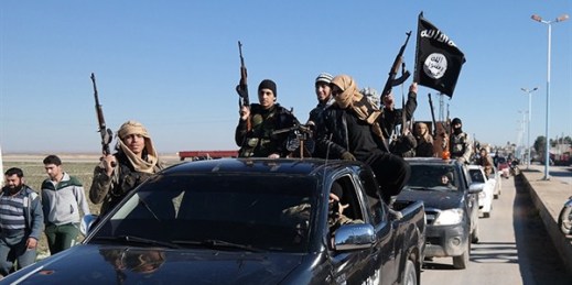 In a photo released on May 4, 2015 by a militant website, which has been verified and is consistent with other AP reporting, Islamic State militants pass by a convoy, Tel Abyad, northeast Syria (Militant website via AP).