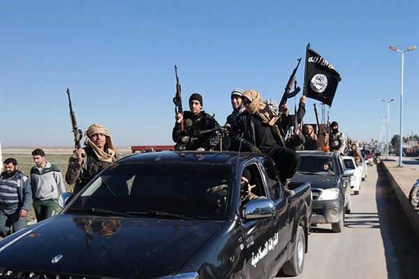 In a photo released on May 4, 2015 by a militant website, which has been verified and is consistent with other AP reporting, Islamic State militants pass by a convoy, Tel Abyad, northeast Syria (Militant website via AP).