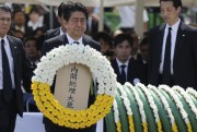 Japanese Prime Minister Shinzo Abe holds a wreath during a ceremony to mark the 70th anniversary of the Nagasaki atomic bombing, Nagasaki, southern Japan Sunday, Aug. 9, 2015 (AP photo by Eugene Hoshiko).