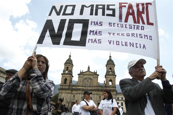 Demonstrators hold a banner that reads in Spanish "No more FARC, no more kidnapping, no more terrorism, no more violence" at a protest against the FARC, Bogota, Colombia, Feb. 15, 2013 (AP photo by Fernando Vergara).