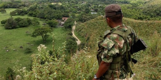 A FARC rebel stands guard on a hill before the release of two hostages, Montealegre, Colombia, Feb. 15, 2013 (AP photo by Juan B. Diaz).