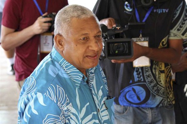 Fiji's then-military ruler Frank Bainimarama arrives at a polling station to cast his vote in a national election, Suva, Fiji, Sept. 17, 2014 (AP photo by Pita Ligaiula).