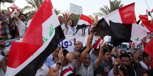 Protesters chant in support of Iraqi Prime Minister Haider al-Abadi as they carry national flags during a demonstration in Tahrir Square, Baghdad, Iraq, Aug. 21, 2015 (AP photo by Karim Kadim).
