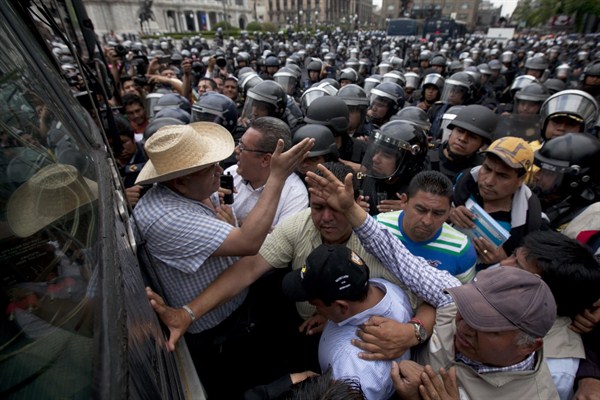 Police prevent demonstrators marking Teacher's Day from approaching the Zocalo plaza in Mexico City, May 15, 2015 (AP photo by Marco Ugarte).