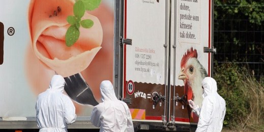 Investigators stand near a truck where 71 migrants were found dead on the shoulder of a highway near Parndorf, south of Vienna, Austria, Aug 27, 2015 (AP photo by Ronald Zak).