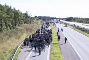 Around 300 migrants walk north on a highway escorted by police in southern Denmark, Sept. 9, 2015 (Rune Aarestrup Pedersen/Polfoto via AP).