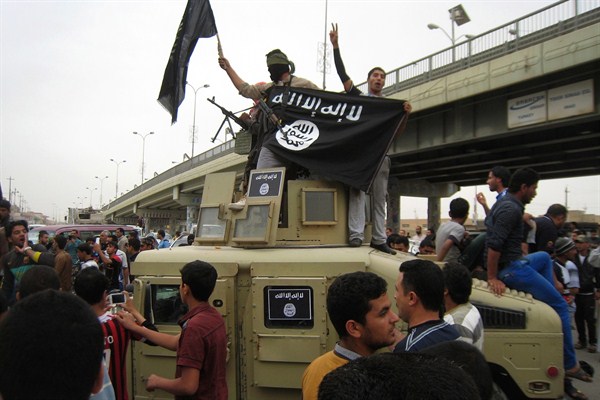 Islamic State fighters wave an Islamic State flag as they patrol in a commandeered Iraqi military vehicle, Fallujah, Iraq, March 20, 2014 (AP photo).