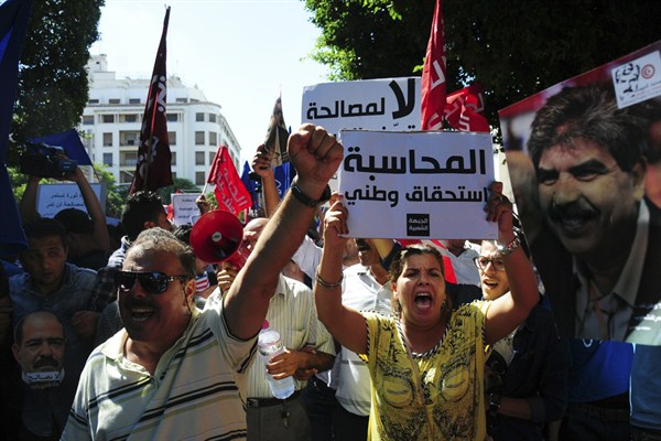 Tunisian demonstrators holding banners that read: "Our Nation Needs Judgement," chant slogans to protest a law offering amnesty for those accused of corruption, Tunis, Tunisia, Sept. 12, 2015 (AP photo by Riadh Dridi).