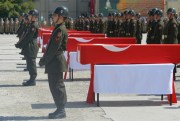 Turkish soldiers stand next to the Turkish flag-draped coffins of eight Turkish soldiers, killed in a roadside bomb, during a ceremony in Siirt, southeastern Turkey, Aug. 20, 2015 (AP photo/Misbah Yilmaz).