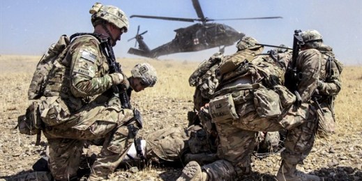 Soldiers prepare a simulated casualty for transport as a UH-60 medevac helicopter lands nearby during live-fire training, Tactical Base Gamberi in eastern Afghanistan, July 2, 2015 (U.S. Army photo by Capt. Charles Emmons).