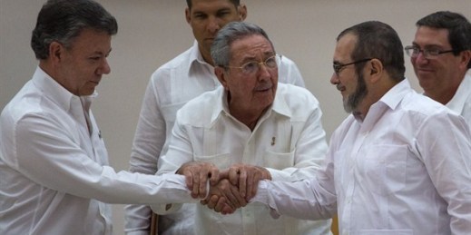 Cuban President Raul Castro encourages Colombian President Juan Manuel Santos and commander the FARC, Timoleon Jimenez, known as Timochenko, to shake hands, Havana, Cuba, Sept. 23, 2015 (AP photo by Desmond Boylan).