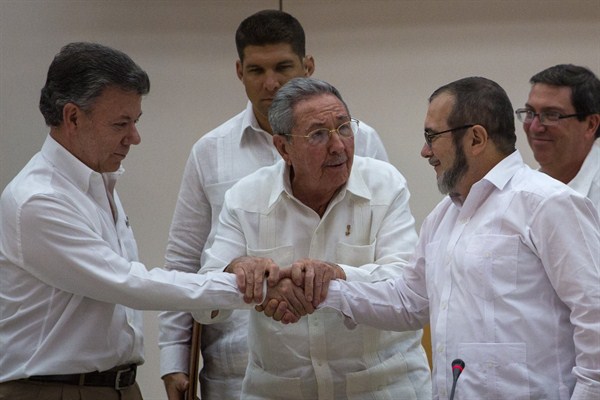 Cuban President Raul Castro encourages Colombian President Juan Manuel Santos and commander the FARC, Timoleon Jimenez, known as Timochenko, to shake hands, Havana, Cuba, Sept. 23, 2015 (AP photo by Desmond Boylan).