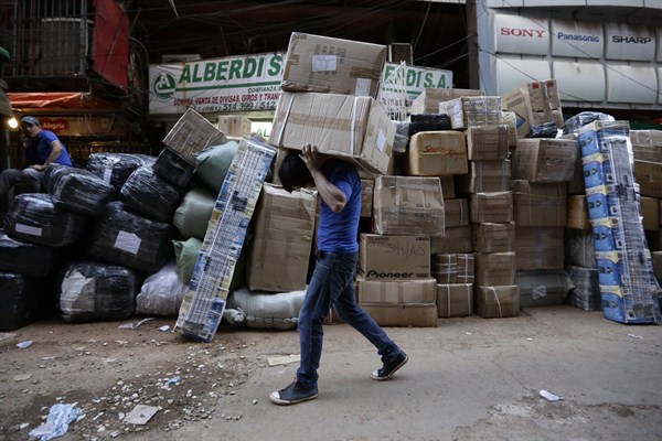 A worker carries packages of goods to send outside the country, Ciudad del Este, Paraguay, May 13, 2015 (AP photo by Jorge Saenz).