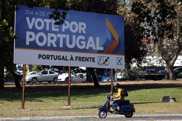 A scooter drives past an election campaign poster of the ruling center-right coalition that reads "Vote for Portugal, Portugal Forward", Lisbon, Oct. 1 2015 (AP photo by Armando Franca).