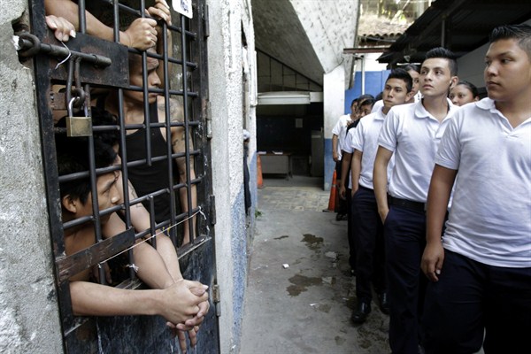 Students walk past inmates as they tour a prison as part of a crime prevention program, San Salvador, El Salvador, Feb. 8, 2012 (AP photo by Luis Romero).