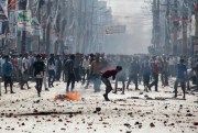 Ethnic Madhesi protesters opposed to Nepal's new constitution throw stones and bricks at Nepalese policemen in Birgunj, near the Indian border, Nepal, Nov. 2, 2015 (AP photo by Jiyalal Sah).