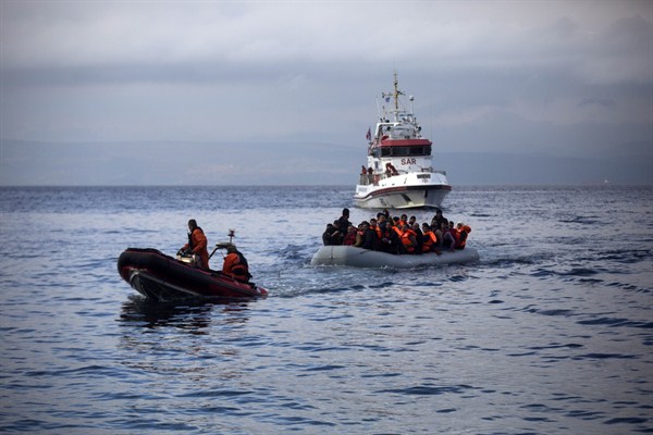 Frontex border guards pull a dinghy with migrants to Skala Sikaminias village on the Greek island of Lesbos, Oct. 21, 2015 (AP photo by Santi Palacios).