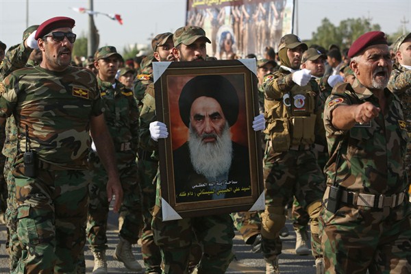 Members of the Abbas combat squad, a Shiite militia group, carry a picture of spiritual leader Grand Ayatollah Ali al-Sistani, Basra, Iraq, Sept. 26, 2015 (AP photo by Nabil al-Jurani).