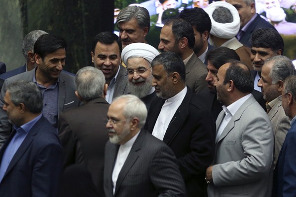 Iranian President Hassan Rouhani surrounded by lawmakers as he arrives at the parliament, Tehran, Iran, Jan. 17, 2016 (AP photo by Vahid Salemi).
