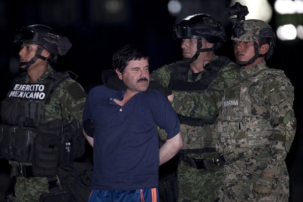 Joaquin "El Chapo" Guzman as he is escorted to a helicopter in handcuffs by Mexican soldiers and marines, Mexico City, Mexico, Jan. 8, 2016 (AP photo by Marco Ugarter).