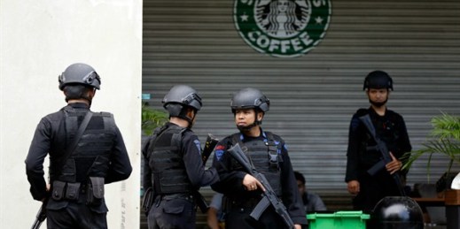Indonesian police officers near a Starbucks cafe where suicide bombers blew themselves up, Jakarta, Jan. 16, 2016 (AP photo by Dita Alangkara).