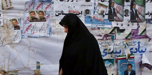 An Iranian woman walks past electoral posters of parliamentary election candidates, Tehran, Iran, Feb. 22, 2016 (AP photo by Vahid Salemi).