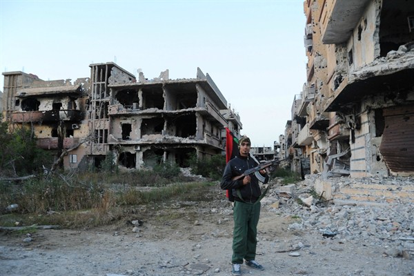 A Libyan in front of damaged buildings, Benghazi, Feb. 23, 2016 (AP photo by Mohammed el-Shaiky).