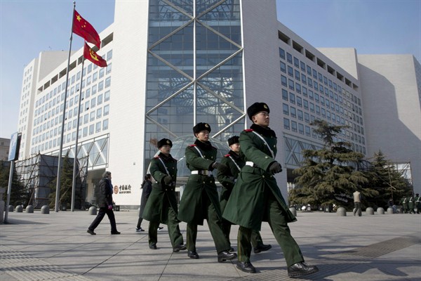 Chinese paramilitary policemen march outside the Bank of China headquarters, Beijing, Feb. 25, 2016 (AP photo by Ng Han Guan).