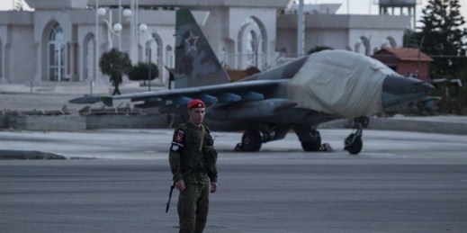 A Russian soldier on guard in front of a Russian ground attack jet parked at Hemeimeem air base, Syria, March 4, 2016 (AP photo by Pavel Golovkin).