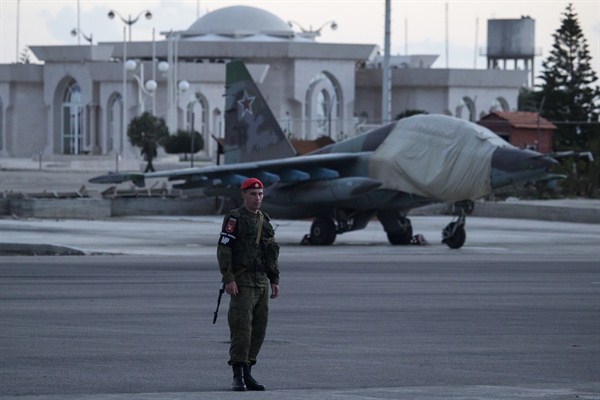 A Russian soldier on guard in front of a Russian ground attack jet parked at Hemeimeem air base, Syria, March 4, 2016 (AP photo by Pavel Golovkin).