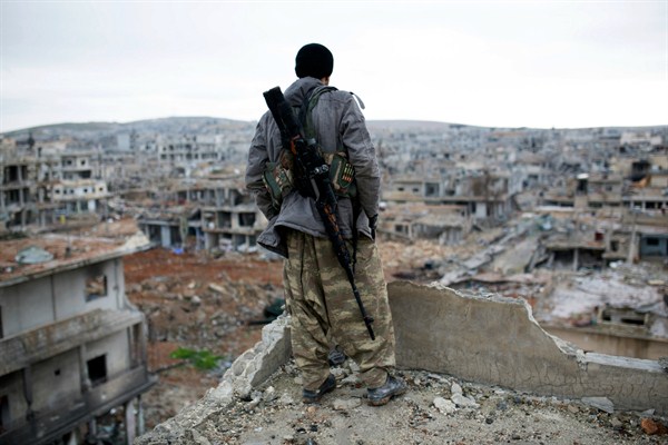 A Syrian Kurdish sniper looks at the rubble, Kobani, Syria, Jan. 30, 2015 (AP photo).