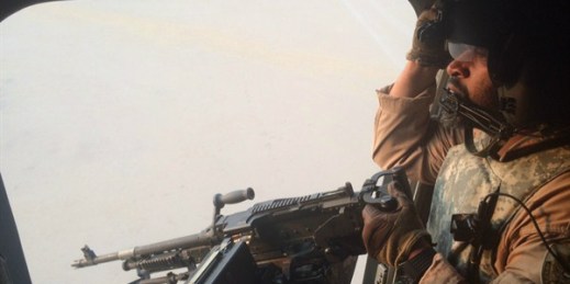An Emirati gunner aboard a Chinook military helicopter, Yemen, Sept. 16, 2015 (AP photo by Adam Schreck).