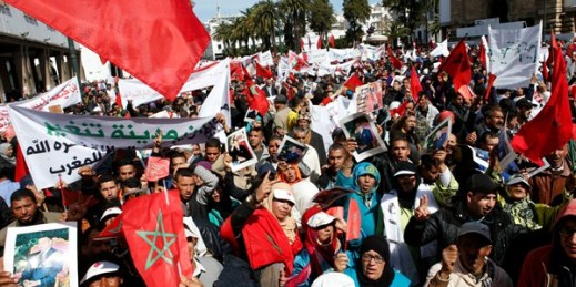 Protesters hold portraits of Morocco's King Mohammed VI and the Moroccan flag during a rally, Rabat, Morocco, March 13, 2016 (AP photo by Abdeljalil Bounhar).