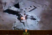 Russian Lt.-Gen. Sergei Rudskoi speaks to the media as a video released by the Russian Defense Ministry shows a target hit in an airstrike on screen, Moscow, Russia, Aug. 10, 2016 (AP photo by Ivan Sekretarev).