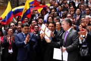 Colombian President Juan Manuel Santos gives Senate President Mauricio Lizcano the peace deal with FARC rebels, Bogota, Colombia, Aug. 25, 2016 (AP photo by Felipe Caicedo).