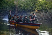 Rebels of the Revolutionary Armed Forces of Colombia, or FARC, patrol the Mecaya river in the southern jungles of Putumayo, Colombia, Aug. 15, 2016 (AP photo by Fernando Vergara).